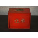 A Chinese bone mah-jong set, in a red lacquered box, with a brass handle to the top, the slide out