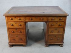 A Victorian mahogany and leather inset twin pedestal writing desk with turned handles raised on