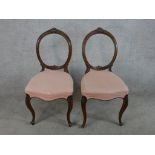 A pair of Victorian walnut balloon back dining chairs with pink stuff over seats, raised on cabriole