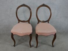 A pair of Victorian walnut balloon back dining chairs with pink stuff over seats, raised on cabriole