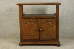 A contemporary oak twin door television cabinet raised on bun feet. H.83 W.79 D.42cm.