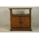 A contemporary oak twin door television cabinet raised on bun feet. H.83 W.79 D.42cm.