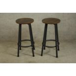 A pair of contemporary painted metal and stained hardwood stools raised on four splayed supports.