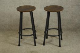 A pair of contemporary painted metal and stained hardwood stools raised on four splayed supports.