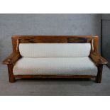 A 20th century tropical hardwood framed settee with cream cotton seat and back cushion. H.85 W.205