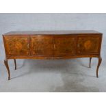 A 20th century walnut veneered serpentine fronted sideboard with four cupboard doors opening to