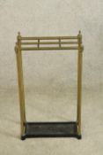 A 19th century brass and iron stick six section umbrella and stick stand raised on fluted