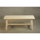 A contemporary limed beech bench raised on four splayed supports with cross stretcher. H.46 W.103cm.