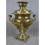 An early 20th century brass twin handled samovar raised on square foot terminating in four hoof