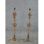 A pair of painted wrought iron Gothic style lamps mounted to wooden supports raised on stepped