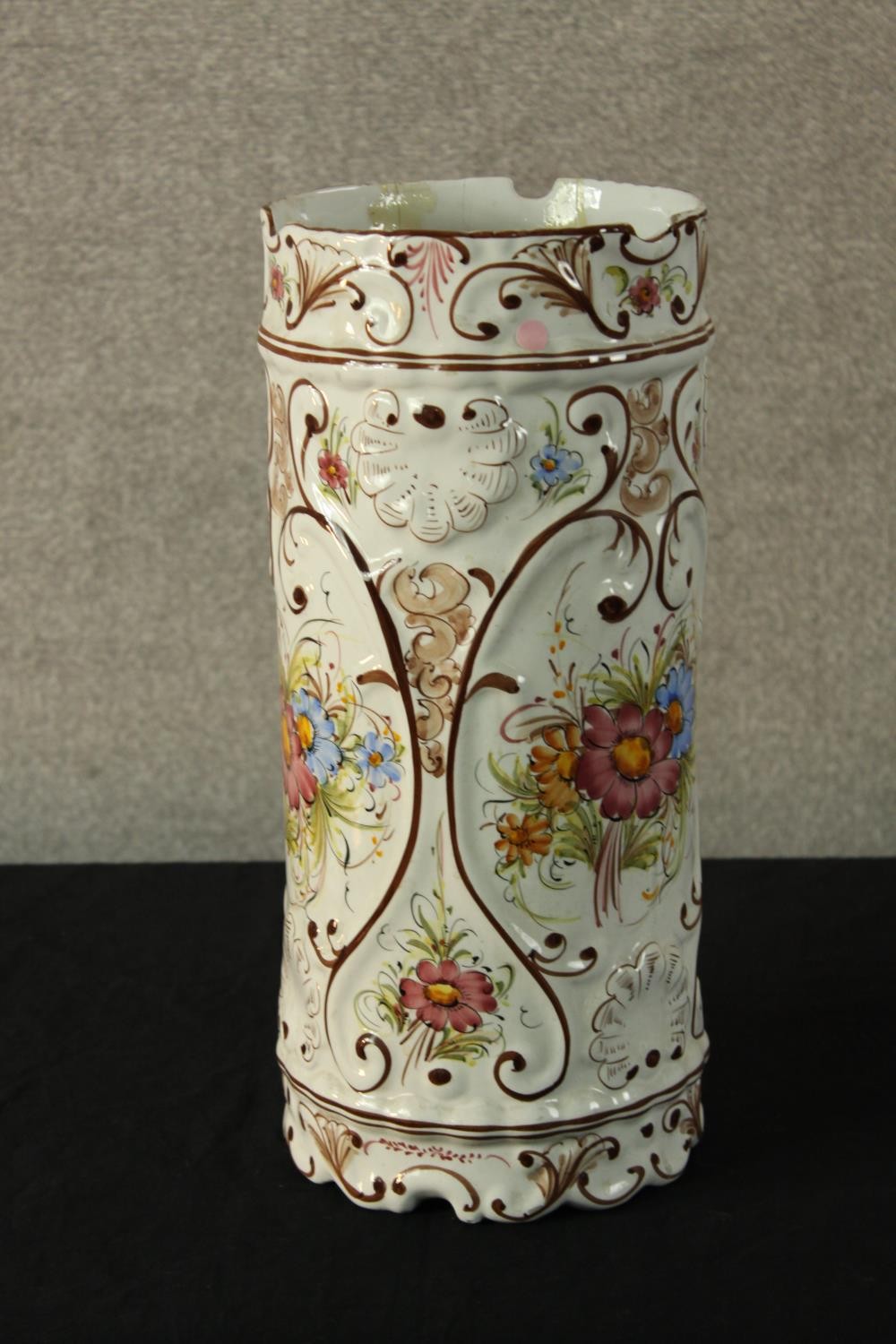 A contemporary Portuguese tin glazed faience cylindrical stick stand decorated with sprays of
