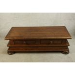 A contemporary teak four drawer coffee table raised on squat bun feet. H.41 W.138 D.68cm.