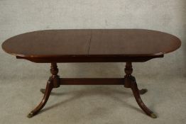 A 20th century Strongbow Furniture mahogany twin pedestal dining table raised on out swept