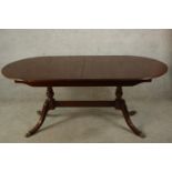 A 20th century Strongbow Furniture mahogany twin pedestal dining table raised on out swept