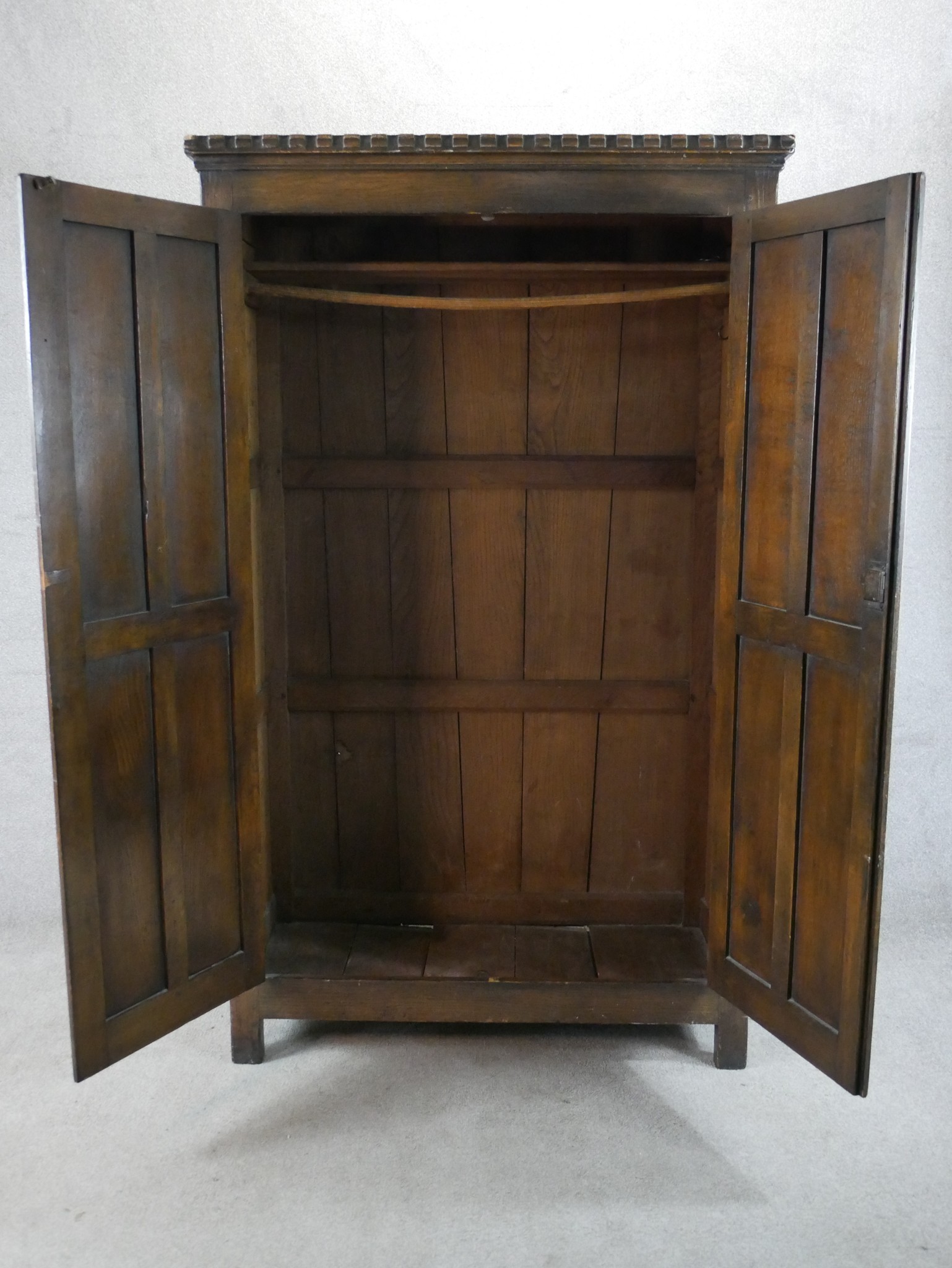 A 20th century stained oak twin door wardrobe with panels of linen fold decoration raised on - Image 5 of 5