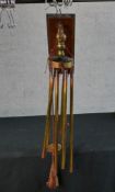An early 20th century copper hanging wind chime instrument mounted on a mahogany wall bracket/panel.