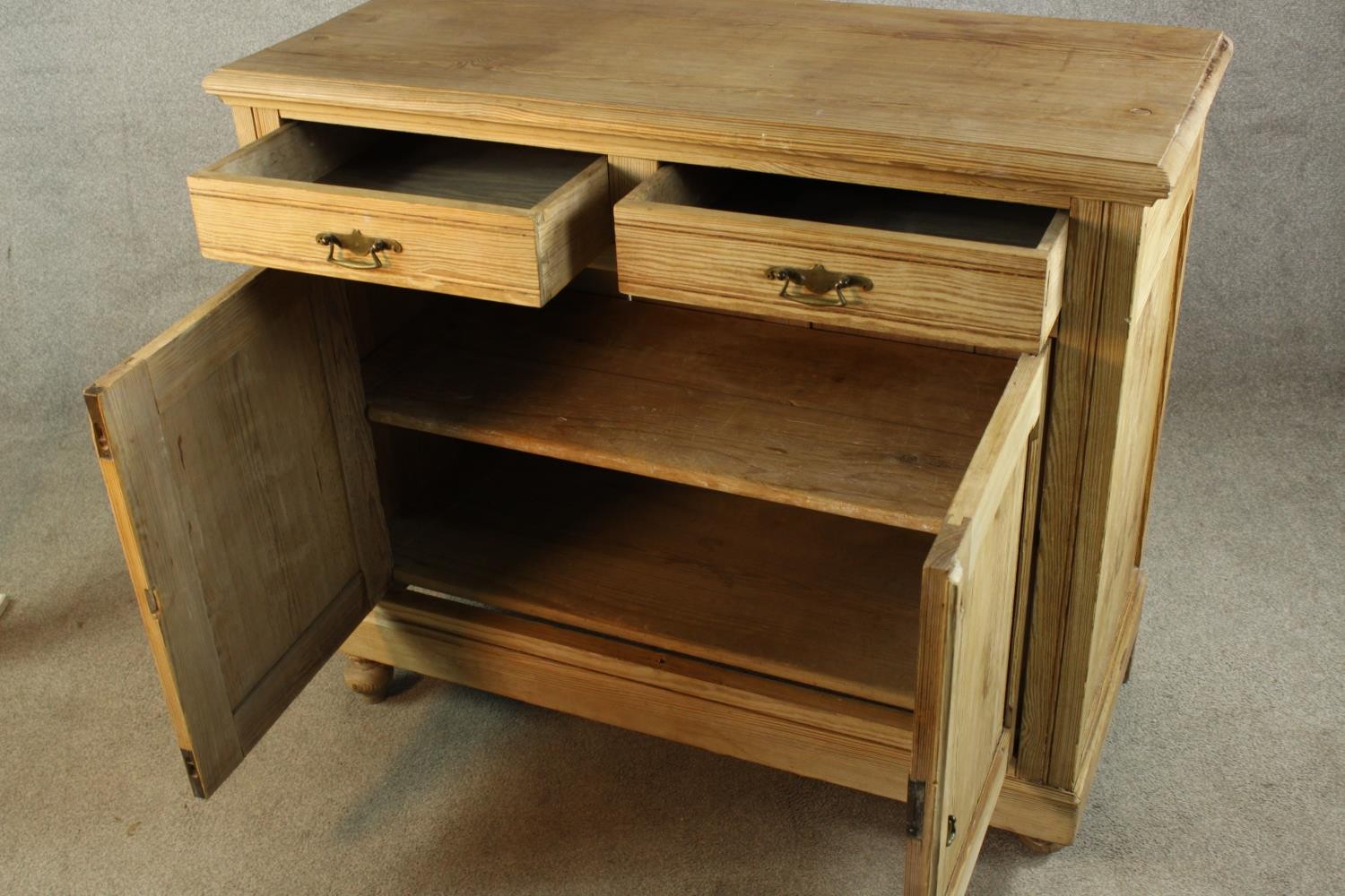 An early 20th century pine two drawer over two door cupboard raised on turned feet. H.95 W.110 D. - Image 4 of 4