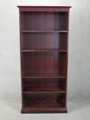 A contemporary mahogany effect floor standing open bookcase raised on plinth base. H.184 W.86 D.35cm