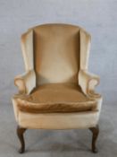 A 19th century mahogany framed wingback chair, upholstered in brown Dralon fabric, raised on