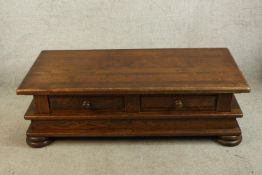 A contemporary teak four drawer coffee table raised on squat bun feet. H.41 W.138 D.68cm.