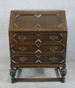 An early 20th century oak fall front bureau, opening to reveal fitted interior with three drawers