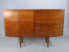 A mid 20th century Danish teak sideboard/drinks cabinet, with single cupboard drawers and drop