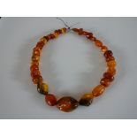 A large string of graduated amber beads, the largest bead measures 3.8cm. L.48cm.