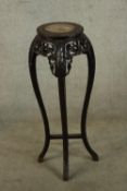 A 19th/early 20th century carved Chinese hardwood and marble plant stand raised on four curved