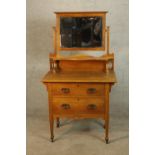 A late 19th/early 20th century mirror back oak two drawer dressing chest raised on turned supports