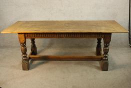 A 19th century carved oak refectory style plank topped table raised on carved turned supports with