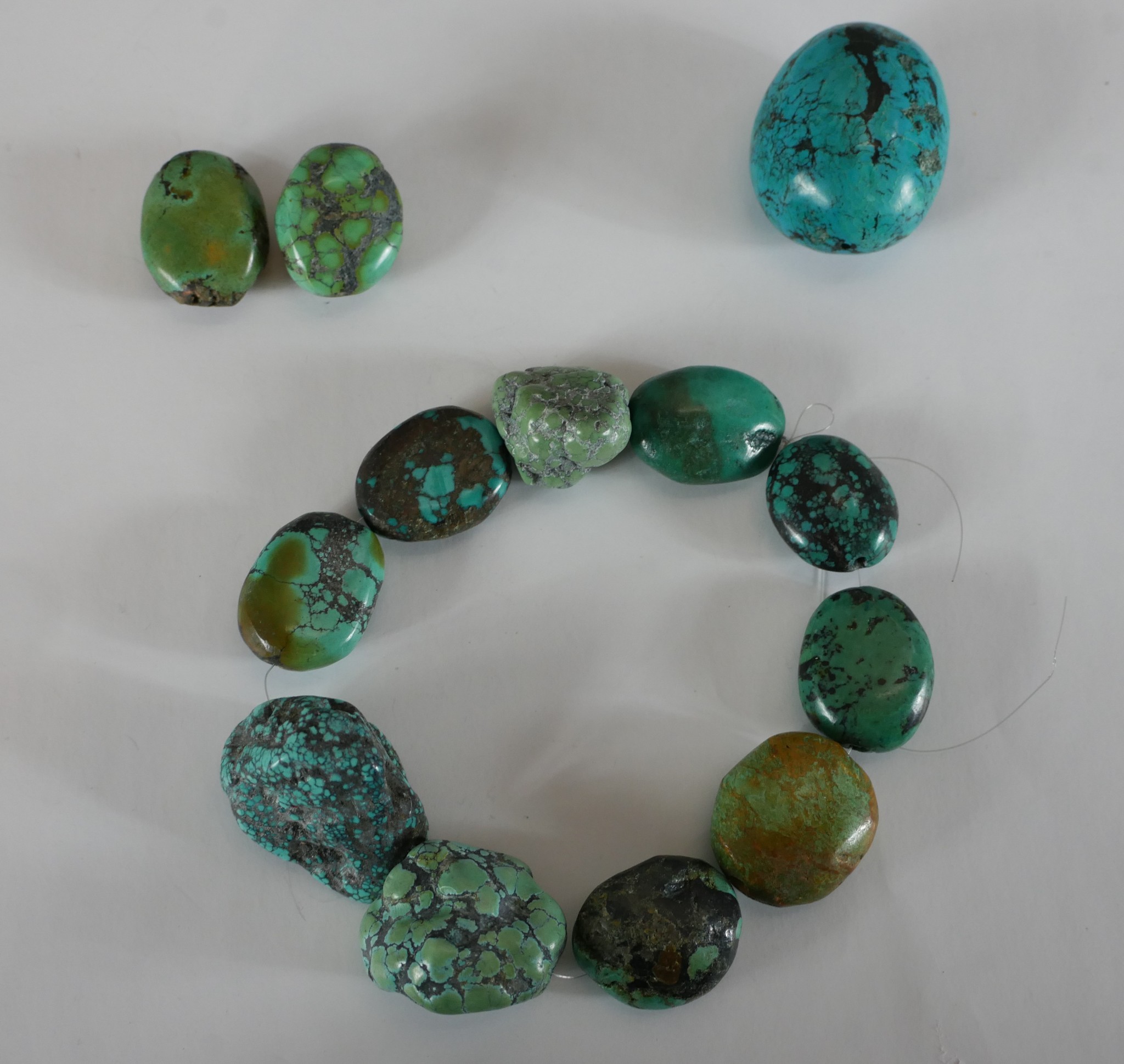 A collection of Turquoise beads, the largest bead measures 4.5cm. H.13 W.13cm largest