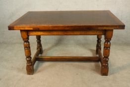 A Jacobean style oak draw leaf dining table raised on turned supports with stretchers. H.75 W.138