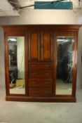 A late 19th century mahogany wardrobe with two mirrored doors flanking two cupboard doors opening to