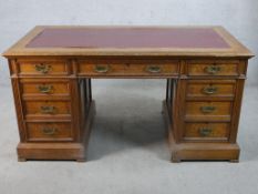 An late 19th/early 20th century oak twin pedestal desk. the central drawer flanked by two