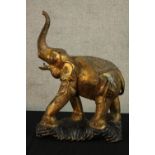 A 20th century cast brass model of a standing elephant raised on a fitted stand. H.62cm.