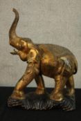 A 20th century cast brass model of a standing elephant raised on a fitted stand. H.62cm.