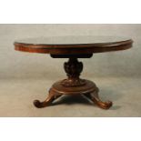 A William IV circular Rosewood tilt top table with carved urn shaped central column raised on four