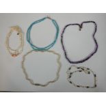 A collection of five vintage necklaces, including an amethyst graduated bead necklace, two sets of