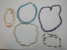 A collection of five vintage necklaces, including an amethyst graduated bead necklace, two sets of