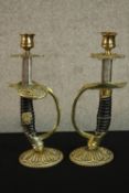 A pair of early 20th century World War I German Officer sword candlesticks raised on brass mounted