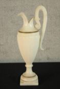 A large 19th/early 20th century carved alabaster ewer, with 'C' scroll handle raised on turned socle