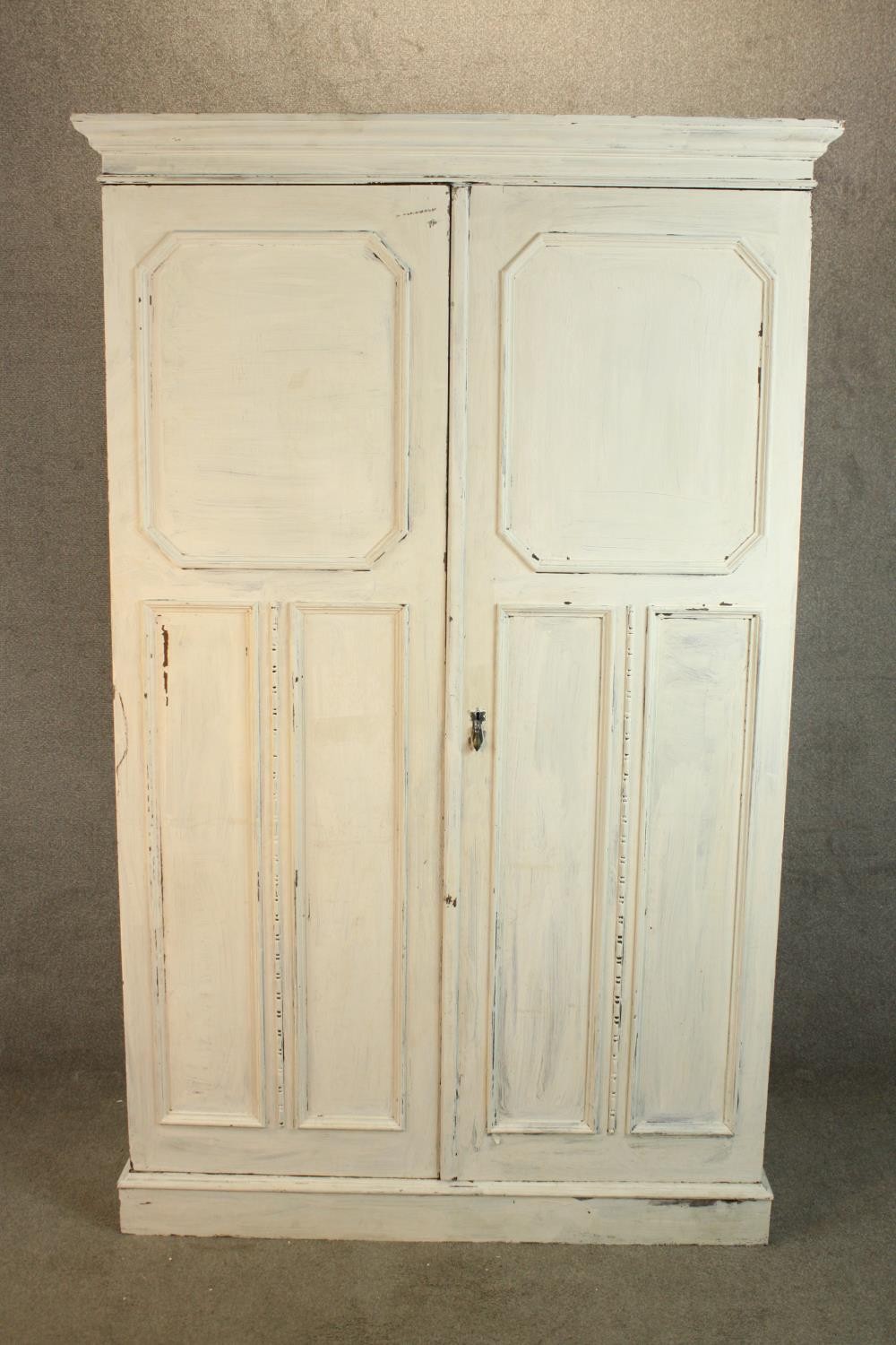 A 1930s white painted oak twin door gentlemen's wardrobe opening to reveal fitted interior raised on