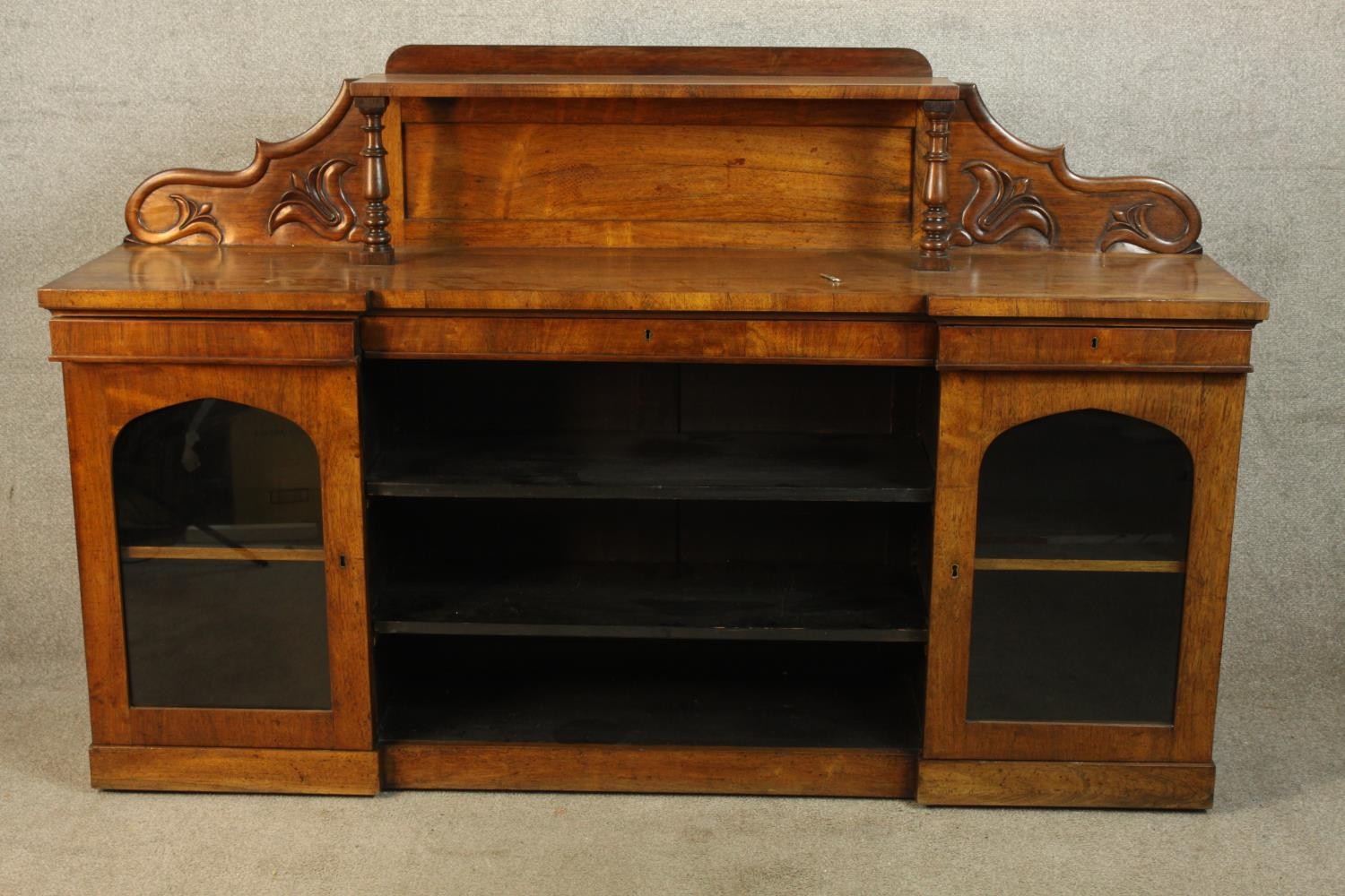 A 19th century walnut twin pedestal sideboard, each pedestal with single glazed door raised on