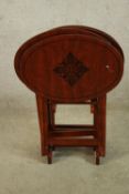 A set of three 20th century mahogany oval topped folding tables with leaf decoration. H.80cm.