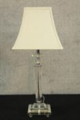 An Art Deco style tapering clear glass stemmed table lamp raised on rectangular base terminating