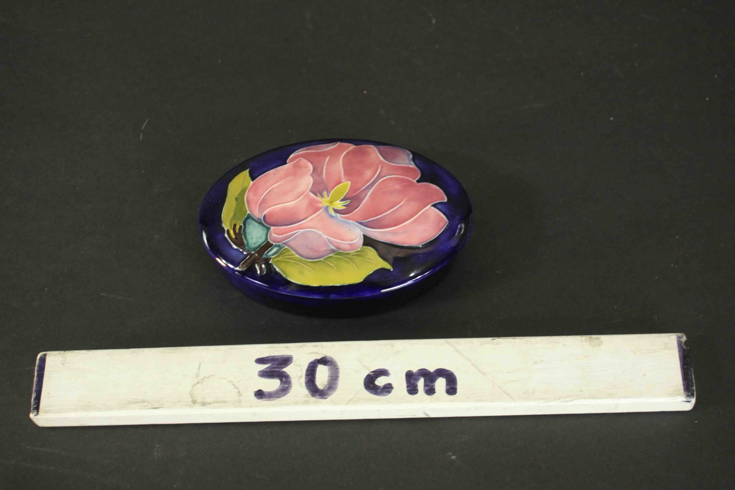 A Moorcroft pink magnolia on blue ground oval powder box. Maker's mark to the base. H.3 W.13cm. - Image 2 of 6