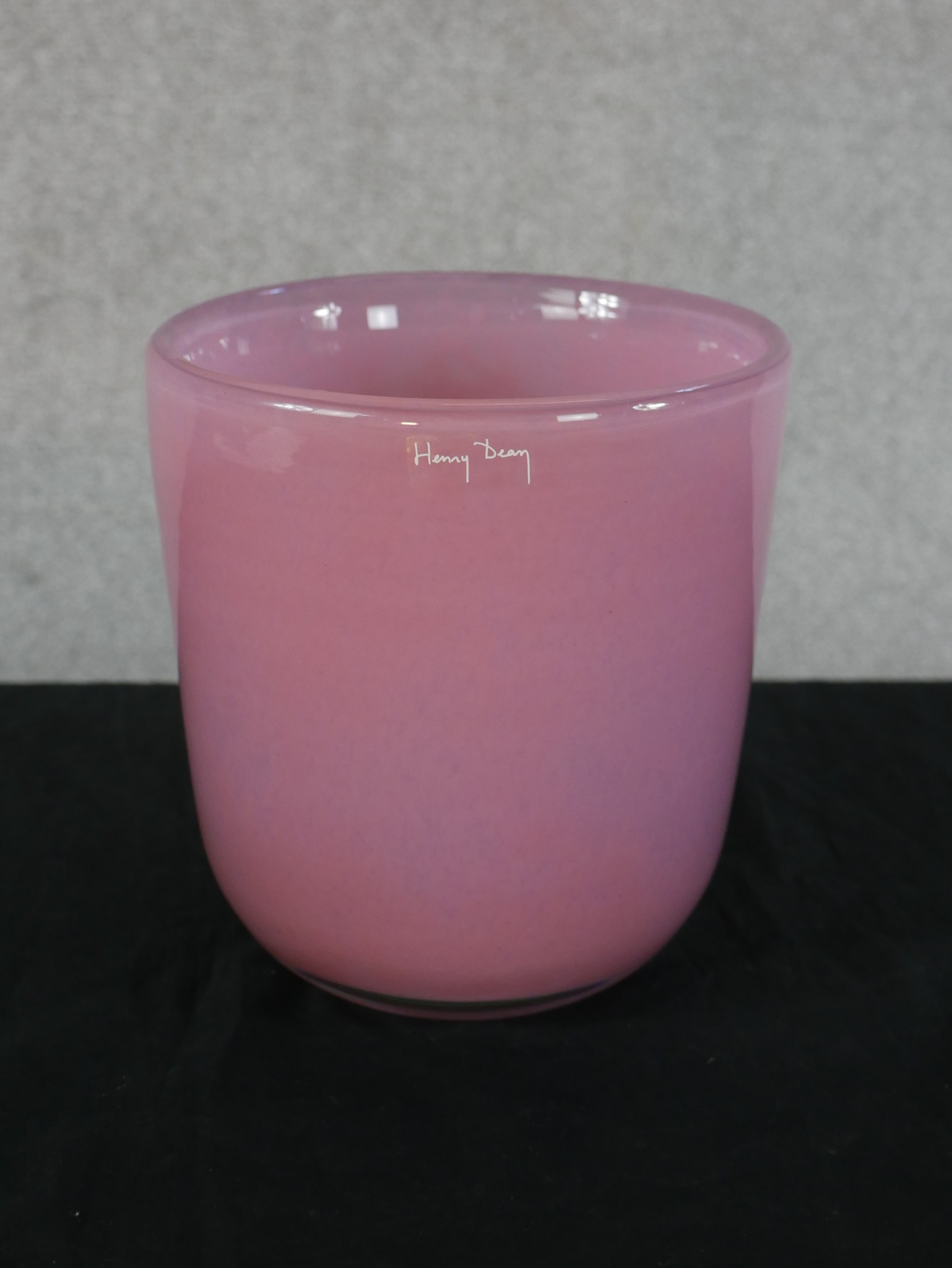 A large studio glass vase by Henry Dean, of cylindrical form in pink, signed to the base. H.19 W.