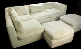 A Oka white cotton L shaped four seater settee together with two footstools. White L shaped