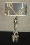 A contemporary silver painted 'intertwining twig' table lamp raised on cylindrical base with