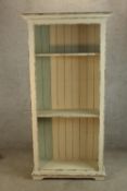 A contemporary painted pine open bookcase raised on shaped bracket feet. H.180 W.90 D.35cm.